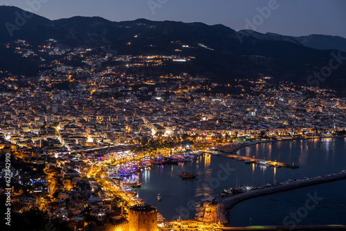 Night city. Alanya, Turkey. Beautiful lights of night city. View of Alanya harbor form Alanya peninsula. Turkish Riviera by night.