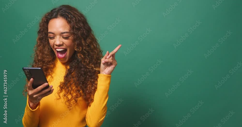 Beautiful young woman points to copy space right, excited, sale, green studio Beautiful young woman points to copy space right, excited, sale, green studio