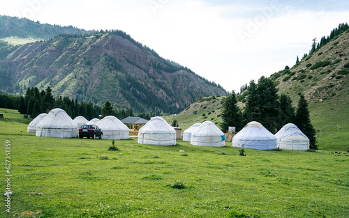 Yurt camp in Karakol Mountains, Tien Shan Mountains, Kyrgyzstan, Central Asia. Traditional nomad's yurts on green mountain meadow in summer