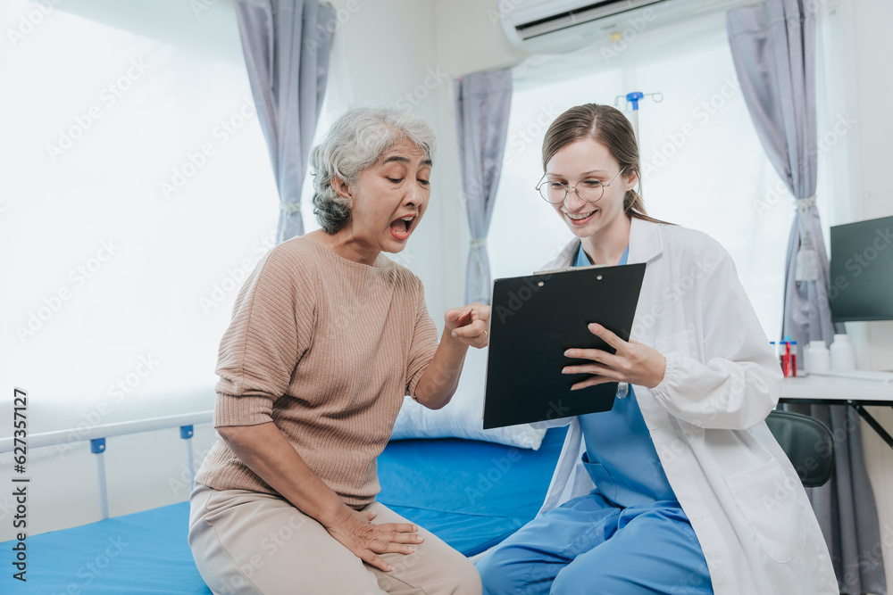 Young beautiful smiling doctor nurse caring to help happy senior grandmother helping old patients in rehabilitation at elderly health checkup Young beautiful smiling doctor nurse caring to help happy senior grandmother helping old patients in rehabilitation at elderly health checkup