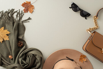 Stylish seasonal accessories. Top view shot presenting a trendy felt hat, cozy scarf, elegant gloves, and a chic handbag on light grey background with empty frame for fashion-forward promotions