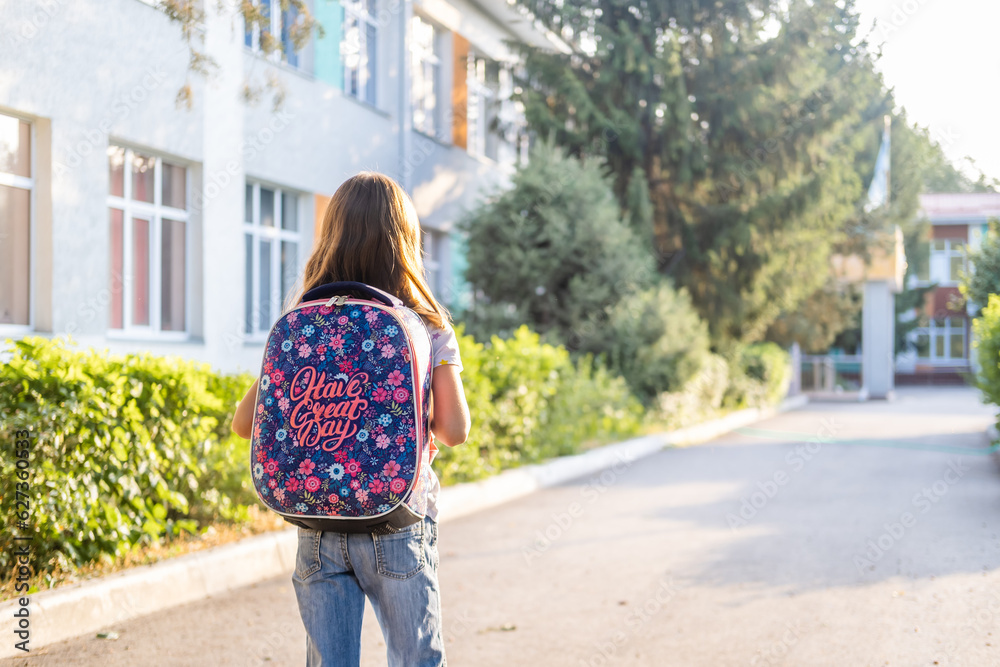 Cute girl with backpack back turned going to school, back to school and education concept