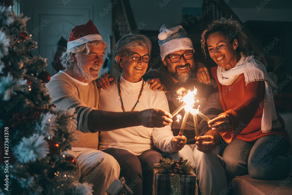 Lovely family group of senior parents and middle aged son with wife celebrating together Christmas holidays and new year with sparkling lights.