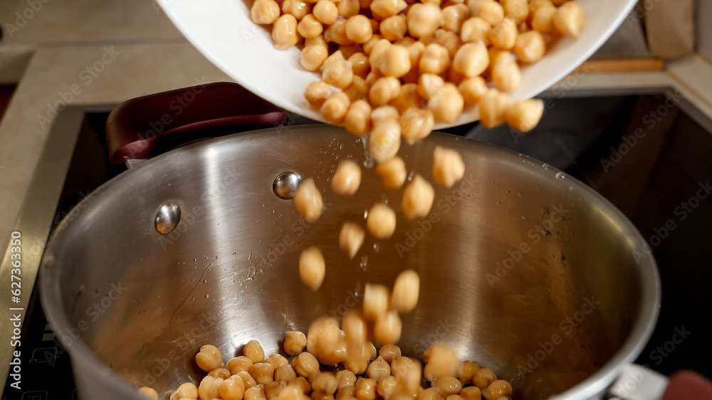 Slow motion of pouring soaked chickpea in pot with water. Legume, healthy nutrition, vegan food. Slow motion of pouring soaked chickpea in pot with water. Legume, healthy nutrition, vegan food.