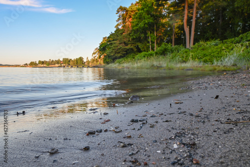 Only a few ripples appear on the still water as water laps the sand on this peaceful morning at the beach. photo