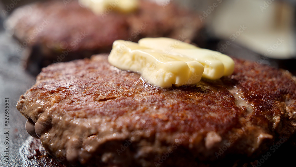 Closeup of butter melting on cooking beef burger patties on grill. Cooking at home, kitchen appliance, healthy nutrition, hamburger ingredients. Closeup of butter melting on cooking beef burger patties on grill. Cooking at home, kitchen appliance, healthy nutrition, hamburger ingredients.
