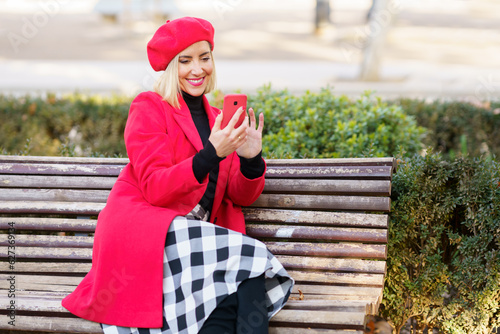 Optimistic woman scrolling social media in park