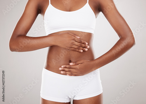 Body, hands and stomach of a woman for health and wellness on a white studio background. Fitness, gut and diet of aesthetic female model for weight loss, colon balance or digestion and motivation