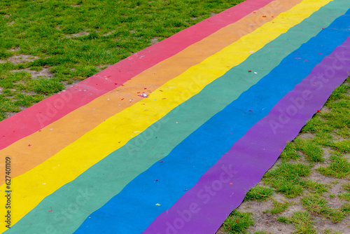 Celebration of pride month, Colourful rainbow walk on the ground with green grass meadow as background, Symbol of Gay, Lesbian, Bisexual and Transgender, LGBTQ community, Worldwide social movements.
