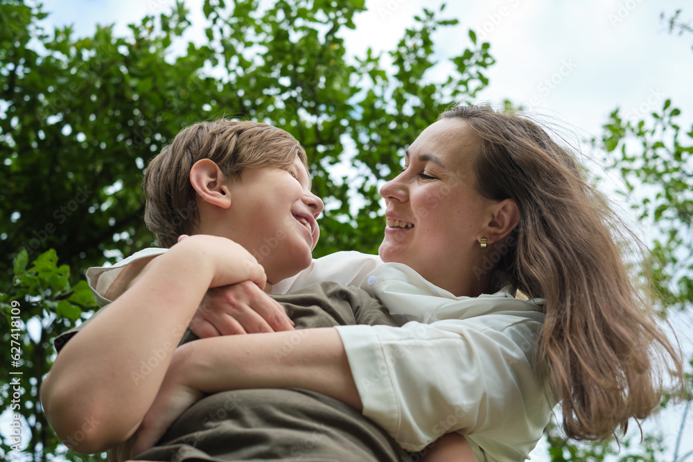 An endearing scene of a mother and son sharing a joke and a hug in a serene garden, highlighting the beauty of natural parent-child connection