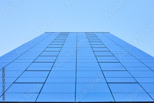 A modern building seen from below, reflecting the sky