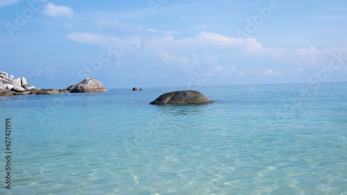 Landscape of large stones on the surface of belitung beach with a view of the clear blue sky. Vacation time and relax with your beloved family
