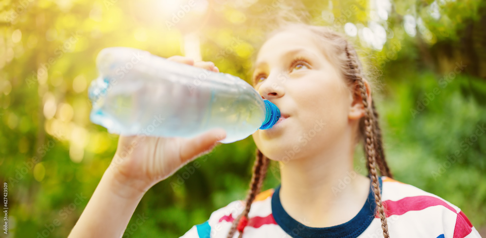 Girl standing in the natural park and drinking water from transparent bottle. Girl standing in the natural park and drinking water from transparent bottle.