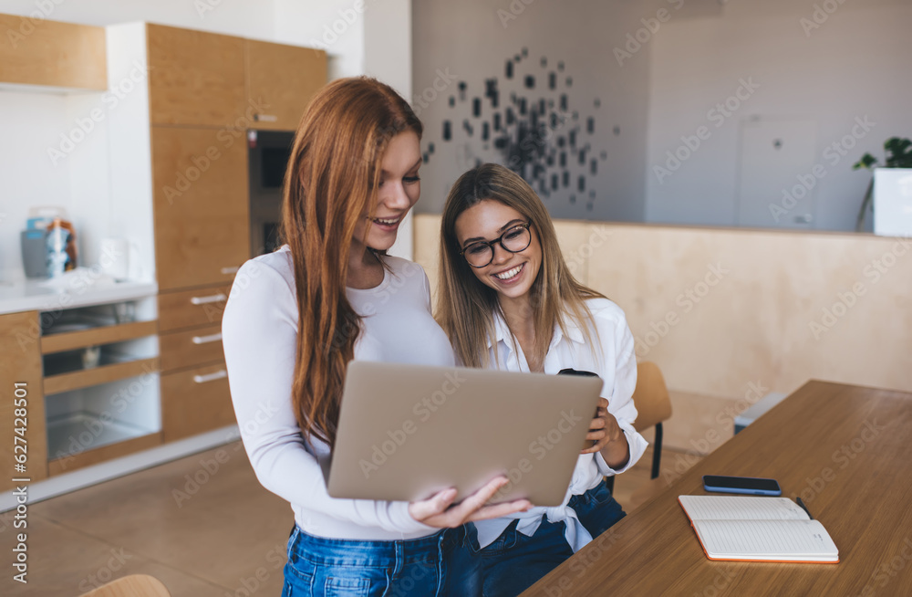 Cheerful women working on project together in office Cheerful women working on project together in office