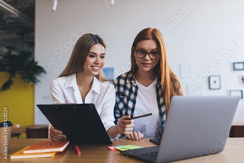 Content women looking at laptop screen while discussing project