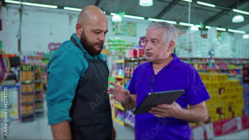Supermarket Manager Addressing Inventory Issue with Employee, Strict Boss Reprimanding Staff Holding Tablet at Grocery Store, Dispute at Workplace