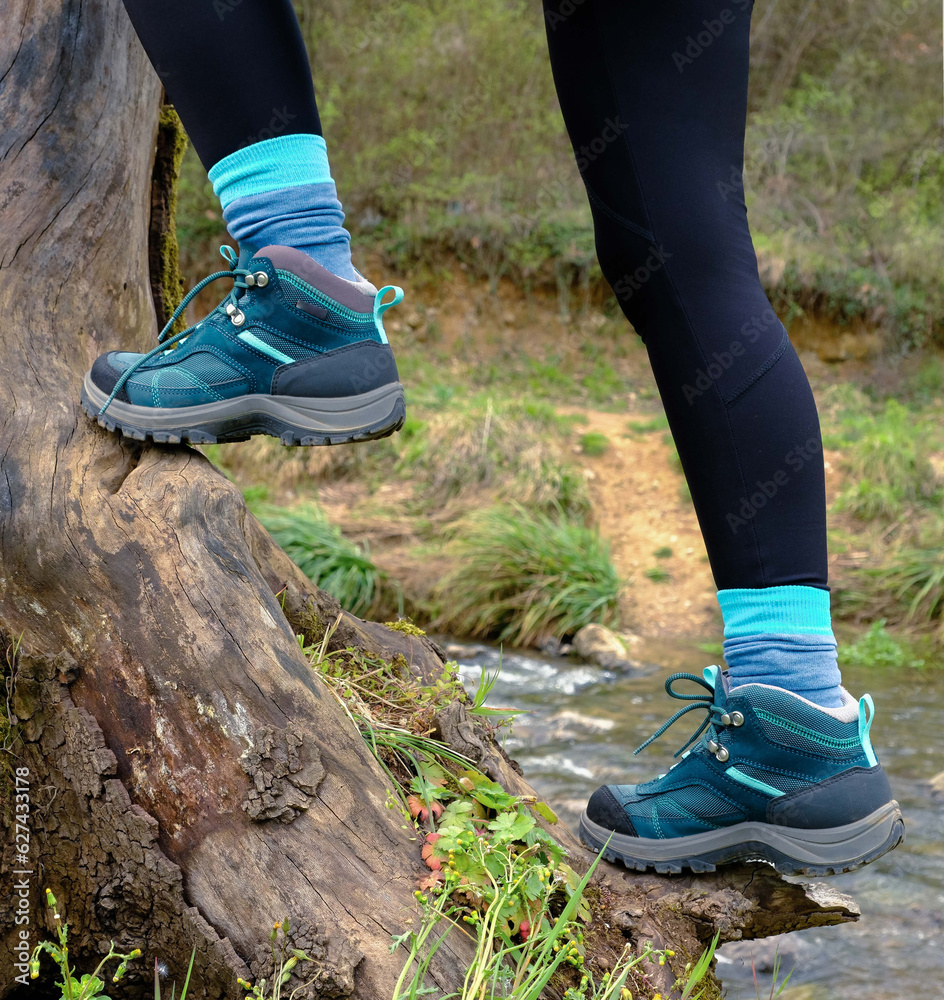 Woman wearing outdoor shoes in the nature, climbing and trekking theme