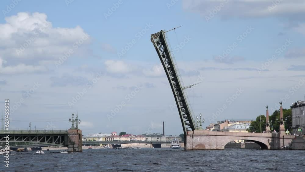 Side view from tour boat of open bascule bridge above Neva river in a cloudy day in Saint petersburg city, Russia. European cityscape. Real time Handheld video. Travel in Russia theme.