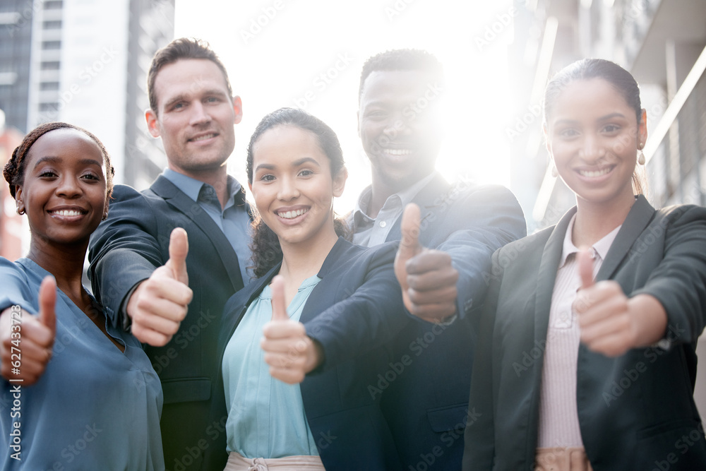 Diversity, portrait of businesspeople and thumbs up smiling in a city background with a lens flare. Collaboration or teamwork, thank you or success and happy colleagues standing in urban outdoors Diversity, portrait of businesspeople and thumbs up smiling in a city background with a lens flare. Collaboration or teamwork, thank you or success and happy colleagues standing in urban outdoors