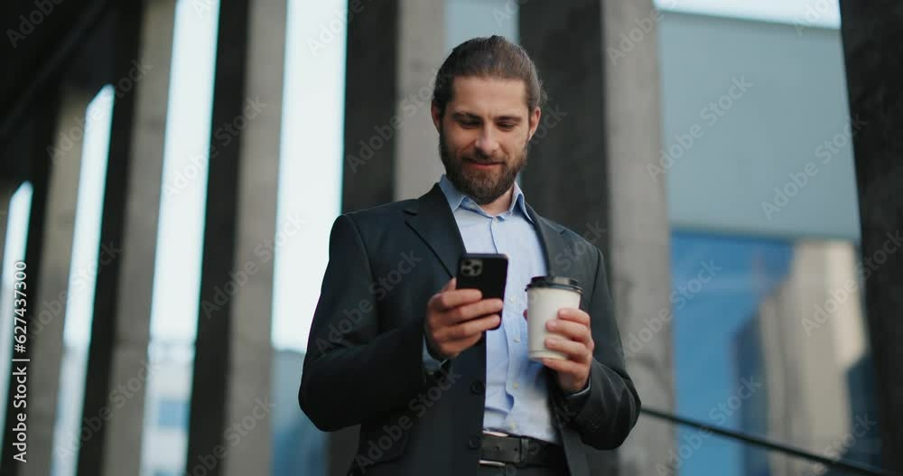 Businessman outside office center while using smartphone and holding coffee. Businessman outside office center while using smartphone and holding coffee.