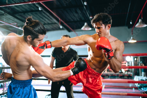 MMA or Thai Boxing match, Two professional fighters punching or boxing, Fit muscular caucasian athletes or boxers fighting, Sport competition and human emotions, Gym atmosphere background