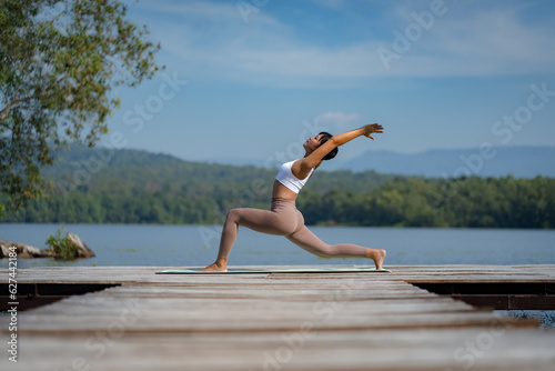 Fitness Asian woman doing yoga in park  Young woman practicing yoga  female happiness in landscape background  Lifestyle of exercise and pose for relax healthy life in the morning nature outdoor
