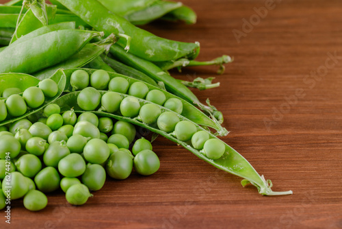 Green pea and pea pods. Pea on wooden table. Closeup of fresh pea. Pea pod with beans.