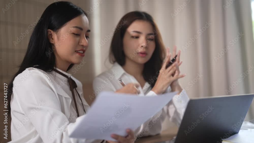 Asian office employee supervising Mentor training intern at office Asian office employee supervising Mentor training intern at office
