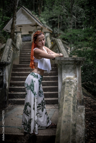 A beautiful girl on an abandoned staircase in the Jungle. Abandoned building. Model girl. Scary jungle.