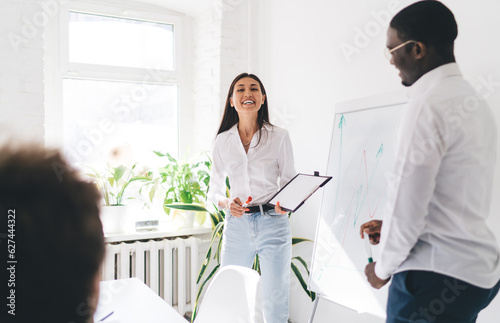 Cheerful diverse colleagues working on project in office