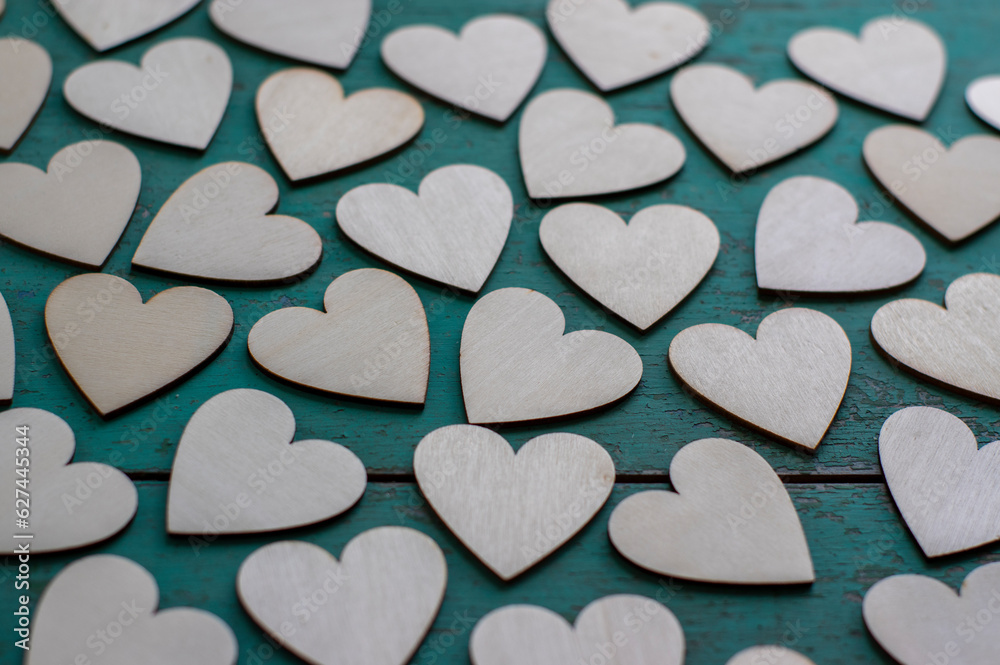 Obraz premium Love Valentines day background, group of light wooden hearts spread on vintage blue green scratched table, flat lay one by one