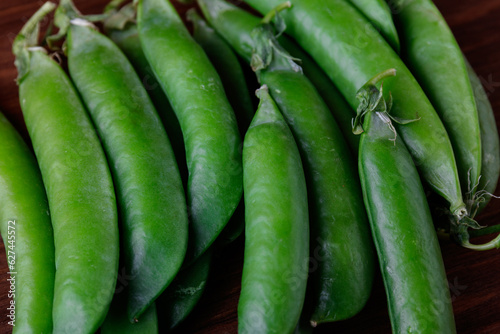 Green pea pods on wooden table. Ripe pea.