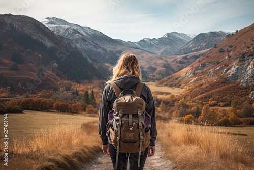 A woman with a backpack walks along the path in the mountains. A female hiker walking to mountains rear view, AI Generated