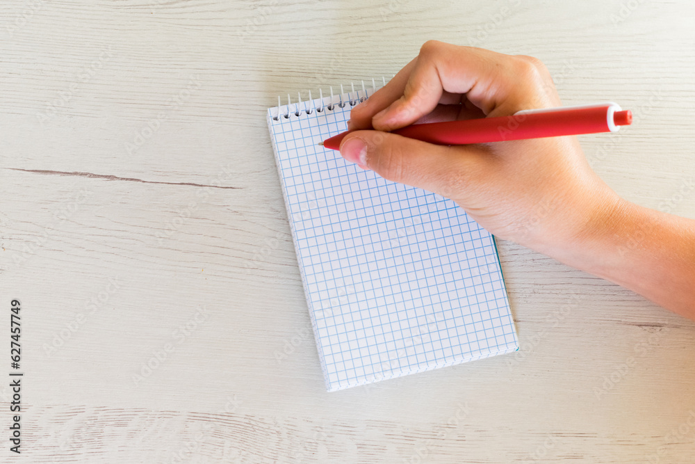 hand with a pen writing in a notebook with blank sheets
hand with a pen writing in a notebook with blank sheets