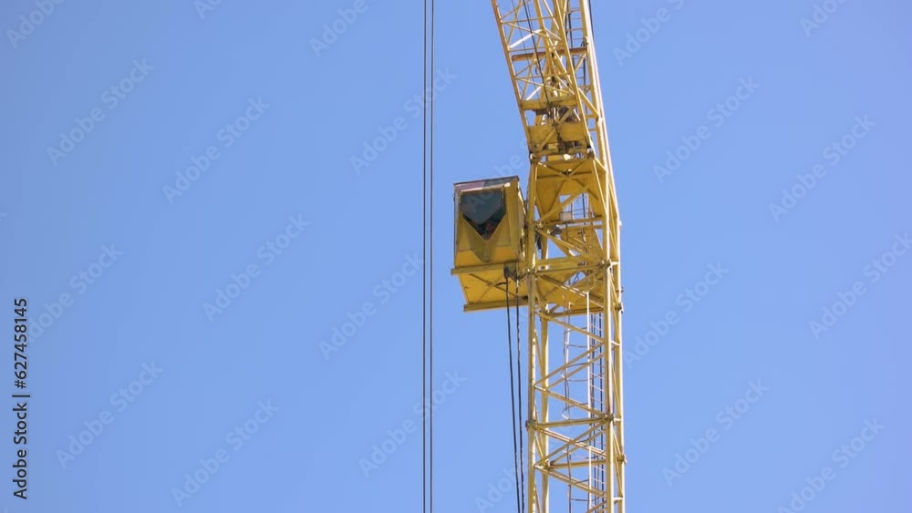Yellow tower crane in the blue sky background. Turn to the left. Yellow tower crane in the blue sky background. Turn to the left.