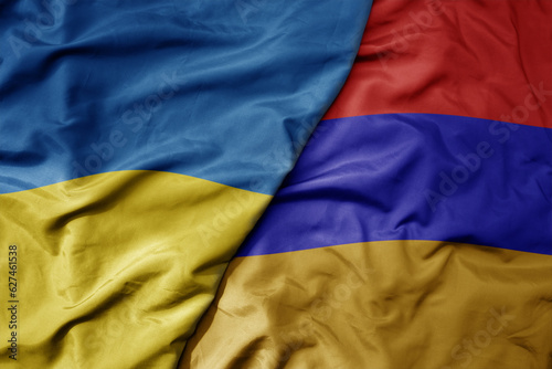 big waving national colorful flag of ukraine and national flag of armenia .