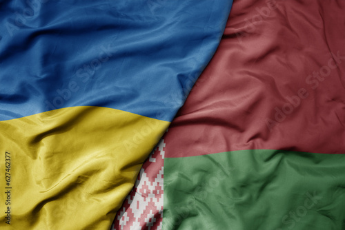 Foto big waving national colorful flag of ukraine and national flag of belarus