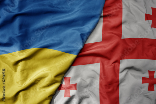 Canvas Print big waving national colorful flag of ukraine and national flag of georgia