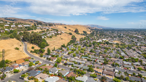 Aerial images over a neighborhood in Hayward, California with a blue sky and room for text. photo