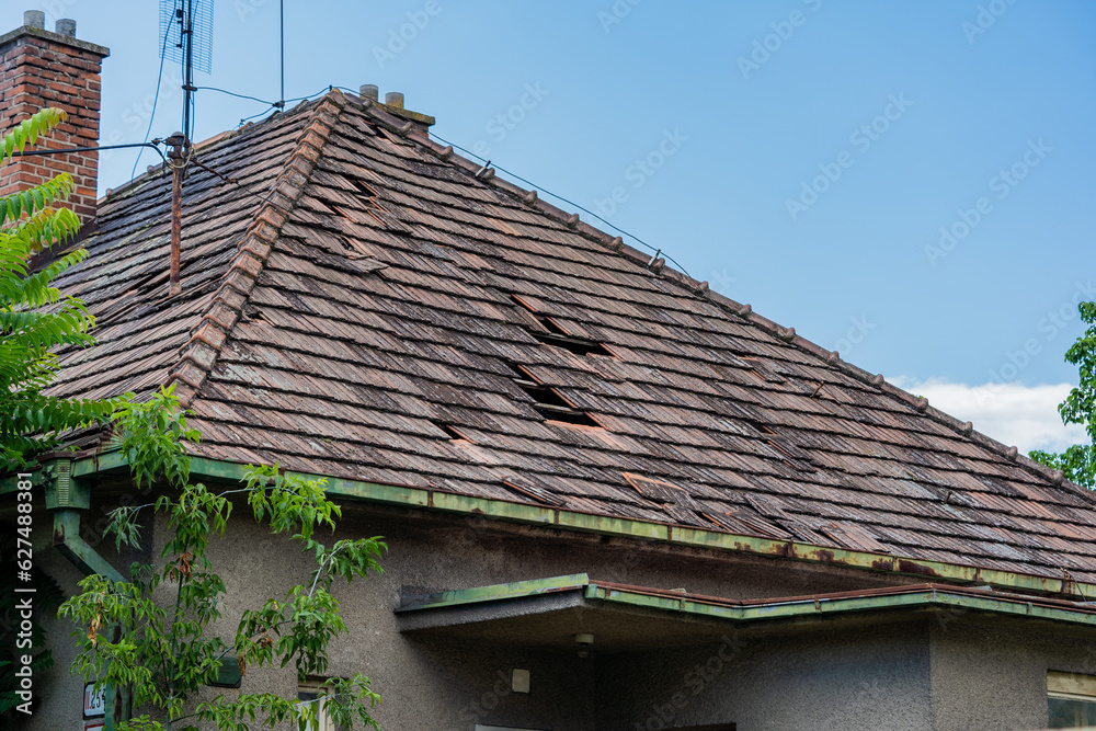 Damaged roof of an old rural house, Exceeded life expectancy, damaged by wind and rain, needs to be replaced. Storm damaged Damaged roof of an old rural house, Exceeded life expectancy, damaged by wind and rain, needs to be replaced. Storm damaged