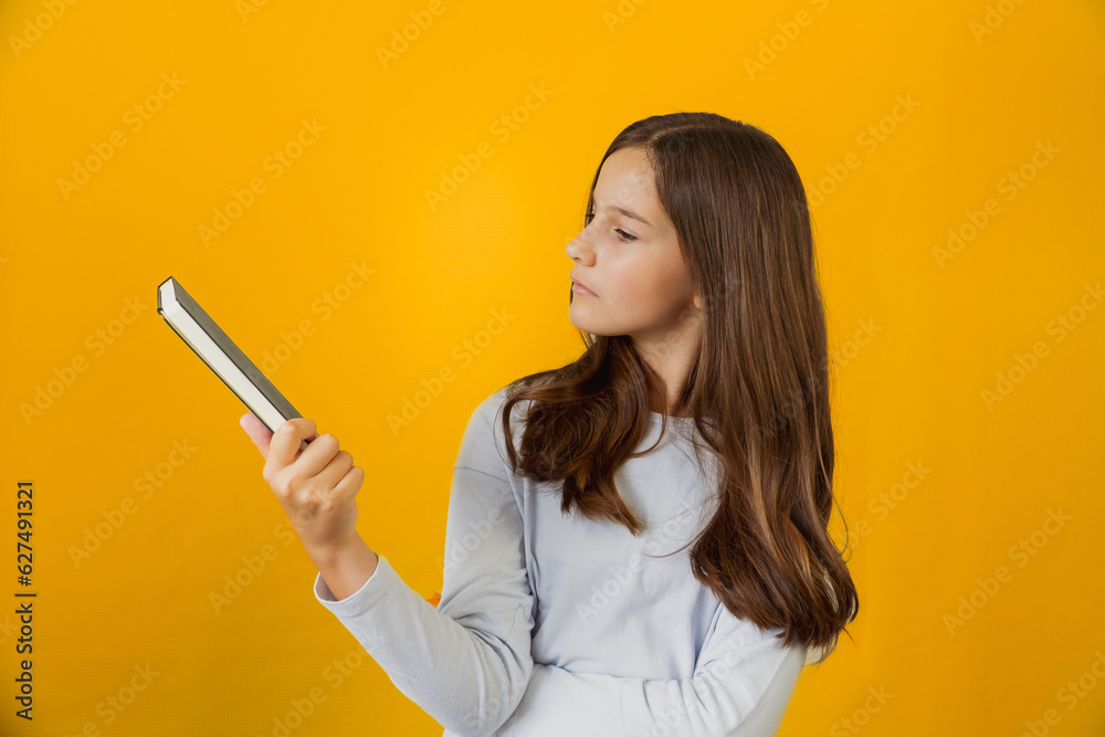 Little cute girl schoolgirl holding notepad book in her hands Little cute girl schoolgirl holding notepad book in her hands