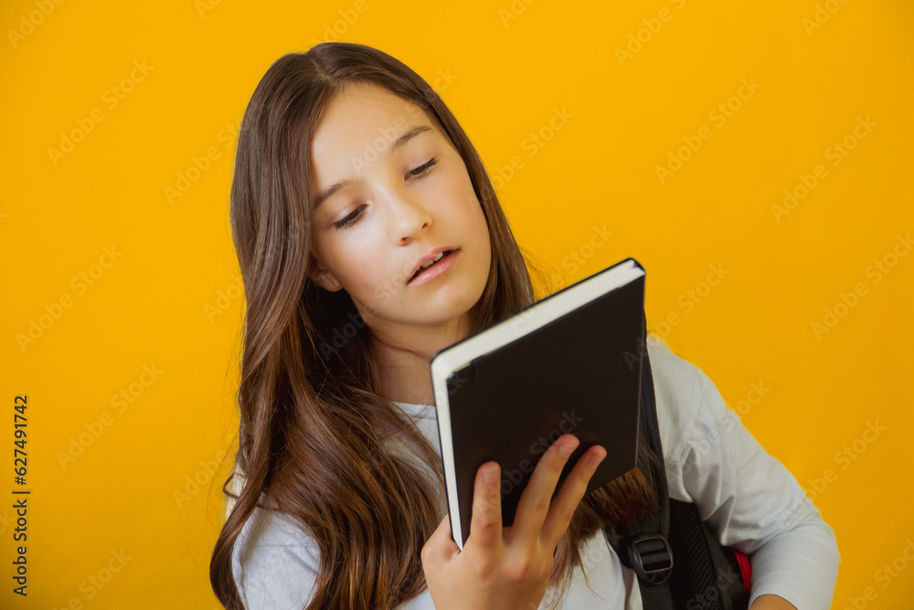 Little cute girl schoolgirl holding notepad book in her hands Little cute girl schoolgirl holding notepad book in her hands