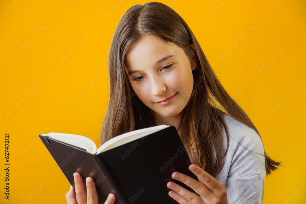 Little cute girl schoolgirl holding notepad book in her hands Little cute girl schoolgirl holding notepad book in her hands