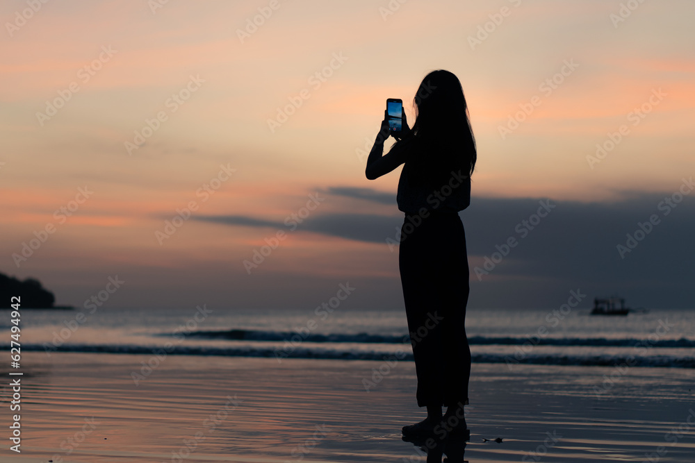 people using smart phone for taking a sunset photo at the beach people using smart phone for taking a sunset photo at the beach
