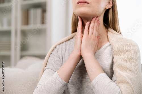 Fotografie Cropped view of woman hands touching lymph nodes on throat