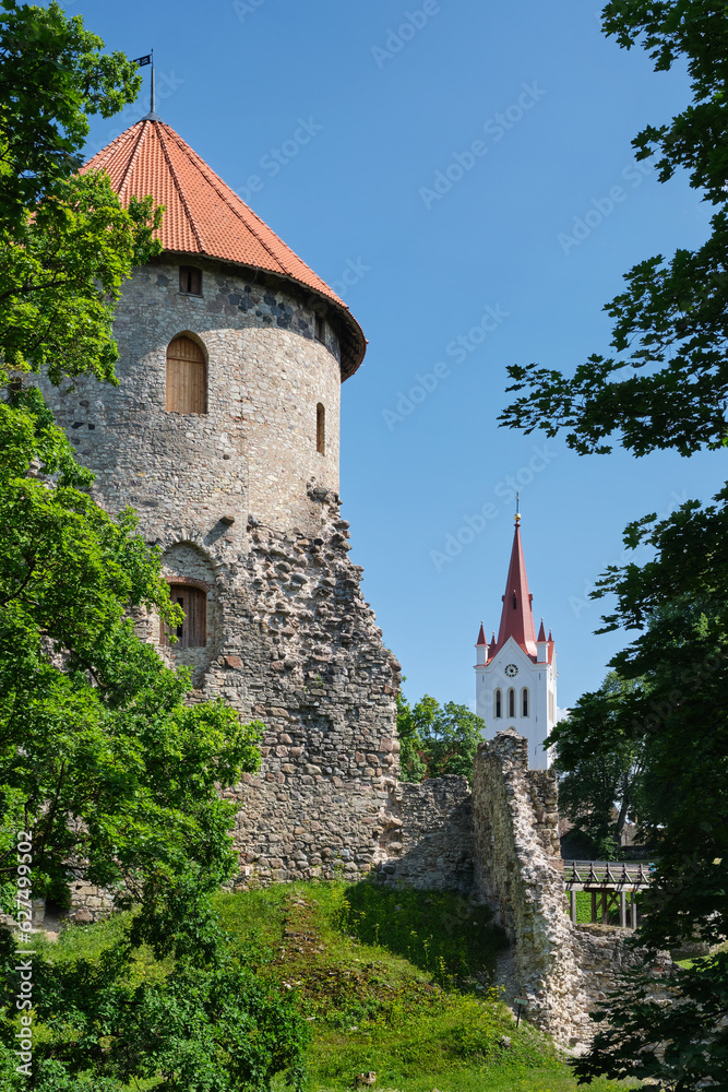 Latvian tourist landmark attraction - tower and ruins of the medieval Cesis Livonian castle and church of Saint John on background. Cesis, Latvia.