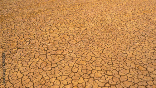 AERIAL: Pattern of cracks on a desolate desert landscape due to lack of rain photo