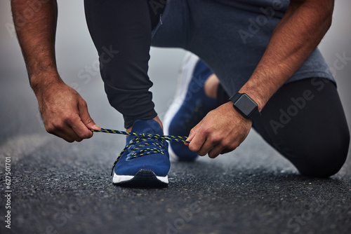 Man, hands and tying shoes on road for running, fitness or cardio workout on asphalt in the outdoors. Hand of male person, runner or athlete tie shoe and getting ready for sports training on street