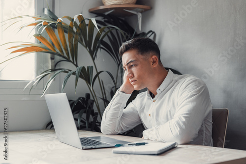 Unhappy young caucasian male worker in glasses look at laptop screen shocked by gadget breakdown or operational problems. Frustrated man confused surprised by unexpected error on computer device..