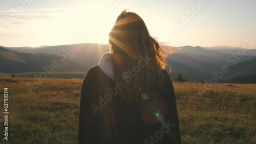 A beautiful Ukrainian young woman traveler walks along the most beautiful high mountain road in Romania Transalpina highway at sunset. Transalpina, Carpathian mountains in Romania at sunrise